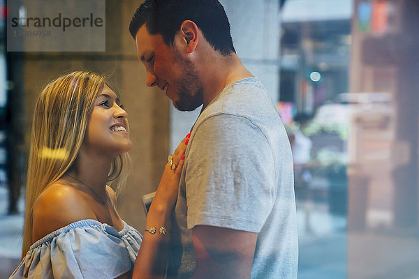 Smiling Caucasian couple behind window