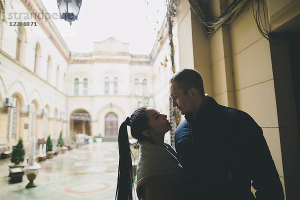 Caucasian couple standing face to face in courtyard