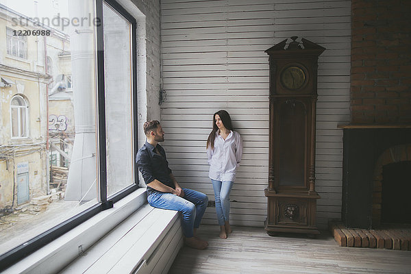 Caucasian couple hanging out near window