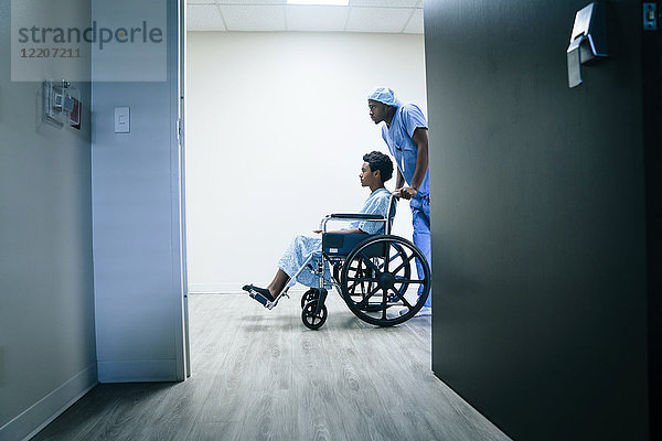 Nurse pushing boy in wheelchair