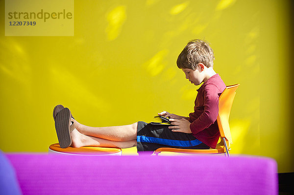 Caucasian boy relaxing and reading digital tablet