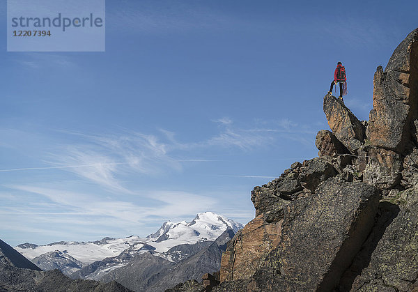 Distant Caucasian man standing on mountain rock
