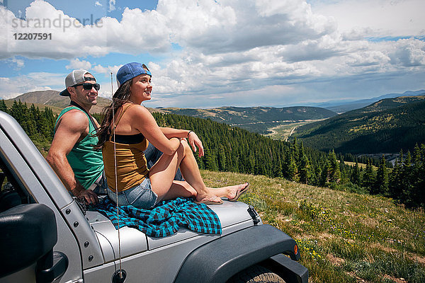 Roadtrip-Paar mit Blick von der Motorhaube in den Rocky Mountains  Breckenridge  Colorado  USA