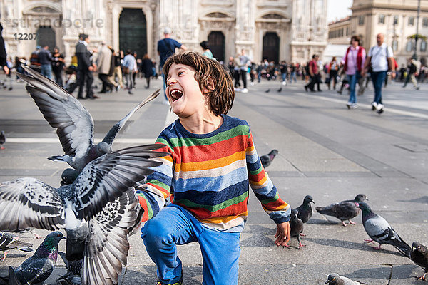 Junge lacht beim Füttern der Tauben auf dem Platz  Mailand  Lombardei  Italien