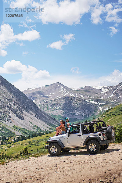 Roadtrip-Paar  das von der Motorhaube eines Geländewagens auf Berge schaut  Breckenridge  Colorado  USA