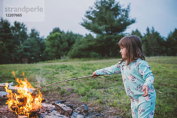 Junges Mädchen röstet Marshmallow im Feuer