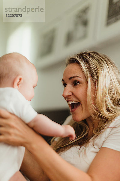 Mutter lächelt Baby-Tochter von Angesicht zu Angesicht an