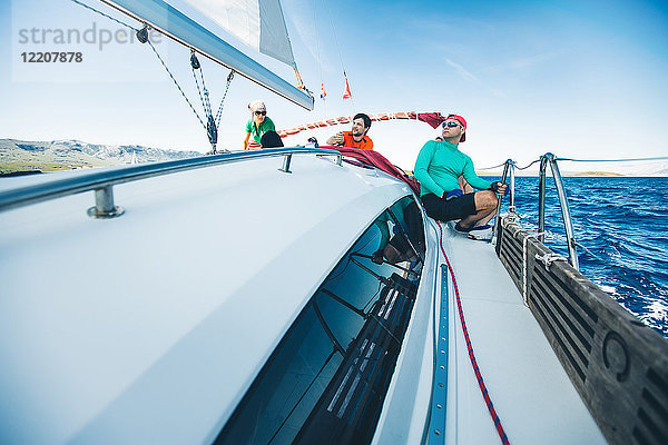 Männer und Frauen beim Segeln in Küstennähe  Kroatien