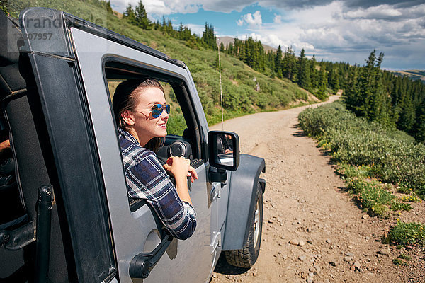 Junge Frau auf Autoreise mit Blick aus dem Autofenster in den Rocky Mountains  Breckenridge  Colorado  USA