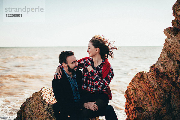 Romantisches Paar mittlerer Erwachsener auf Strandfelsen sitzend  Oblast Odessa  Ukraine
