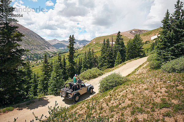 Roadtrip-Ehepaar mit Blick auf die Rocky Mountains aus einem Vierrad-Cabriolet  Breckenridge  Colorado  USA