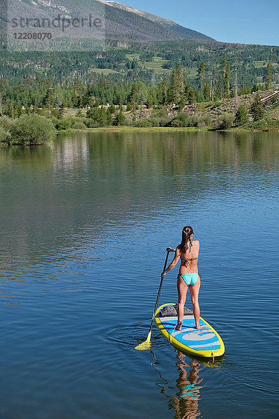 Rückansicht einer jungen Frau beim Paddelbootfahren im Stehen auf einem See  Frisco  Colorado  USA