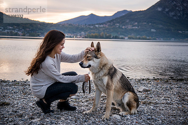 Junge Frau streichelt Hund am Flussufer  Vercurago  Lombardei  Italien