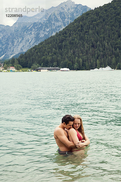 Paar mit tiefer Taille im Wasser umarmend  Achensee  Innsbruck  Tirol  Österreich  Europa