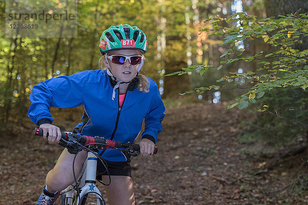 Mountainbike-Mädchen bereitet sich auf das Radfahren im Wald vor