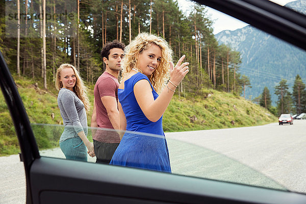 Blick durch das Autofenster von Freunden  die vor der Kamera über die Schulter schauen  Innsbruck  Tirol  Österreich  Europa