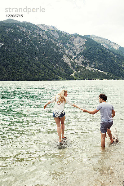 Paar im flachen Wasser Händchen haltend  Achensee  Innsbruck  Tirol  Österreich  Europa