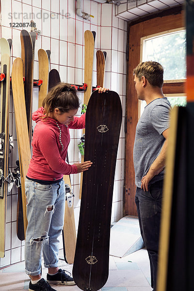 Mann und Frau in der Werkstatt  inspizieren Skiausrüstung