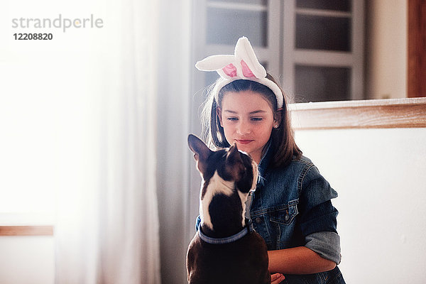 Mädchen sitzend mit Hund  drinnen  Mädchen mit Osterhasenohren