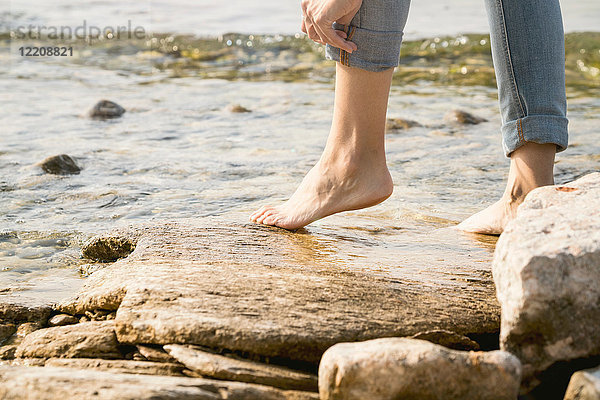 Schrägansicht einer barfüssigen Frau auf Felsen