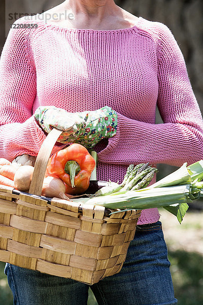 Frau mit Korb mit selbst angebautem Gemüse