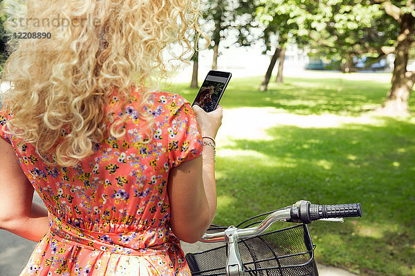 Frau mit Fahrrad mit Smartphone