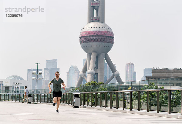 Junge männliche Läufer laufen im Finanzzentrum von Shanghai  Shanghai  China