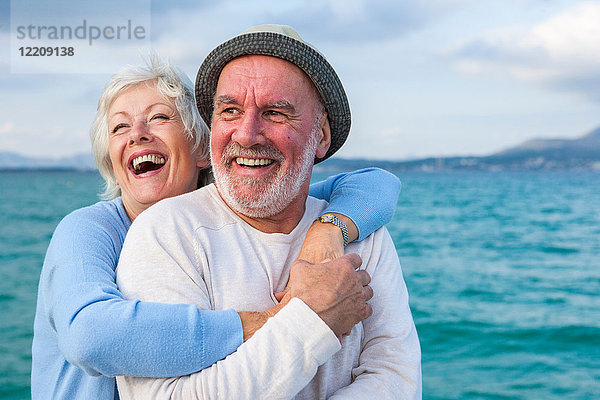 Paare  die sich am Meer umarmen und lachen