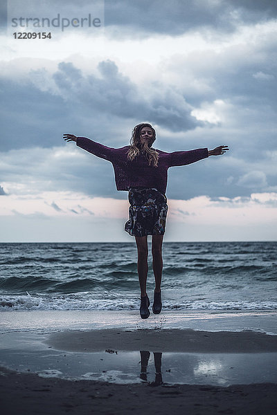 Porträt einer jungen Frau  die in der Abenddämmerung am Strand springt  Oblast Odessa  Ukraine