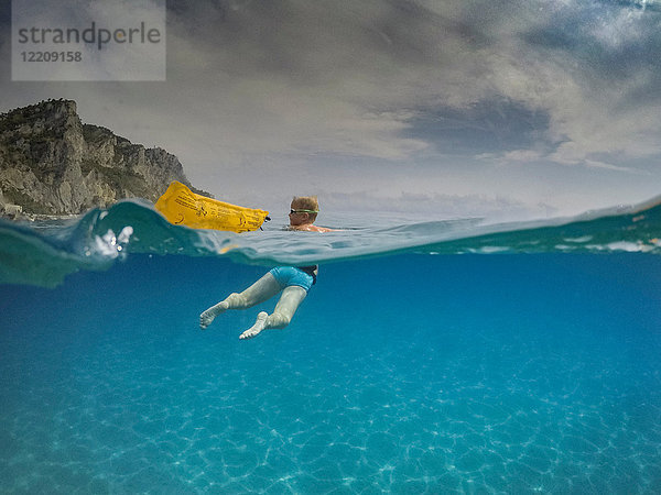 Unterwasseransicht eines Jungen  der beim Schwimmen im blauen Meer zurückblickt  Varigotti  Ligurien  Italien