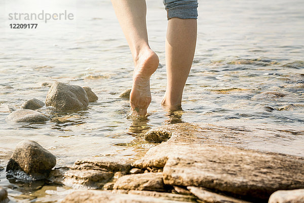 Schrägansicht einer barfüssigen Frau im Wasser