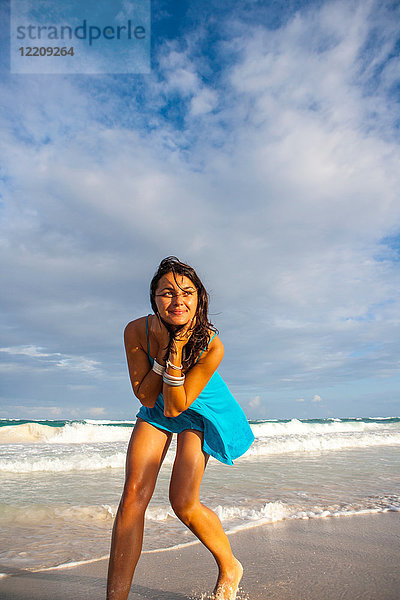 Junge Frau im Sonnenkleid spielt am Strand  Tulum  Quintana Roo  Mexiko