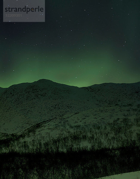 Nordlicht über schneebedeckten Hügeln bei Nacht  Finnmark  Norwegen