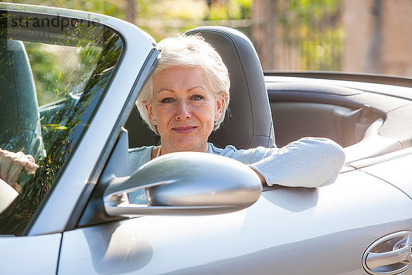 Porträt einer älteren Frau in einem Cabriolet