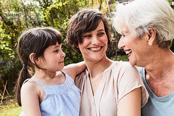Porträt einer älteren Frau mit erwachsener Tochter und Enkelin  im Freien  lächelnd