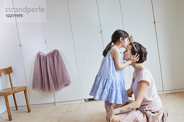 Mutter und Tochter im Schlafzimmer  von Angesicht zu Angesicht  Tochter küsst Mutter auf den Kopf