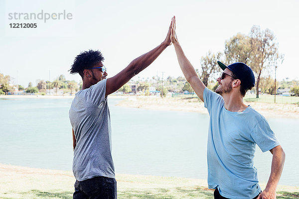 Freunde machen High Five am See  Long Beach  Kalifornien  USA