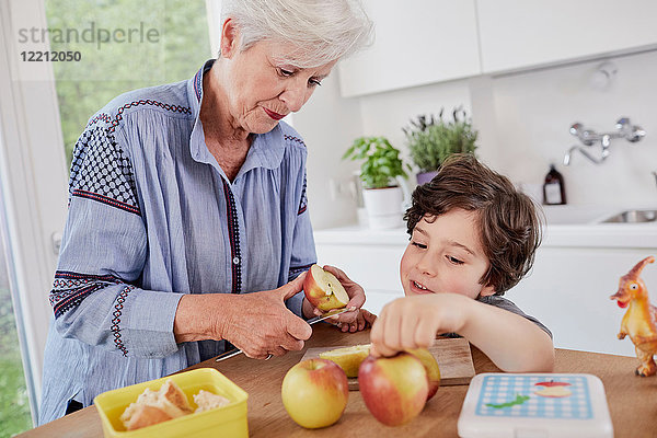 Großmutter und Enkel bereiten das Essen in der Küche zu