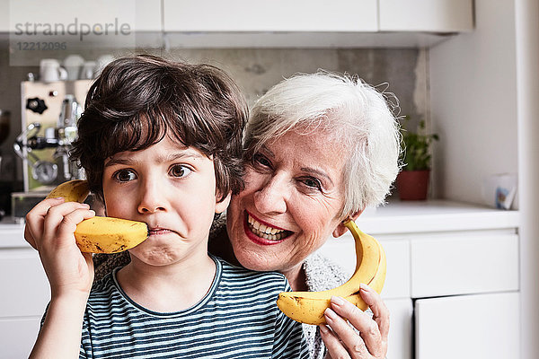Großmutter und Enkel albern herum  benutzen Bananen als Telefon  lachen