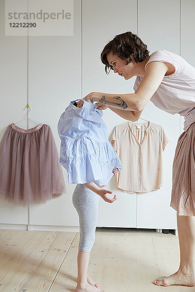 Mutter hilft Tochter beim Anziehen