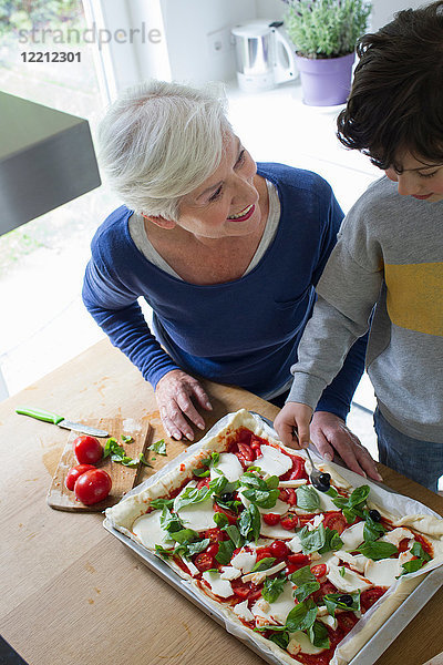 Großmutter und Enkel machen zusammen Pizza