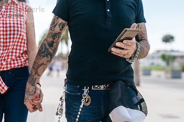 Tätowiertes Hipster-Pärchen  das Hände und Smartphone hält  Mittelteil