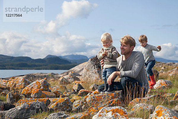 Mann mit Söhnen spielt am Fjord  Aure  More og Romsdal  Norwegen