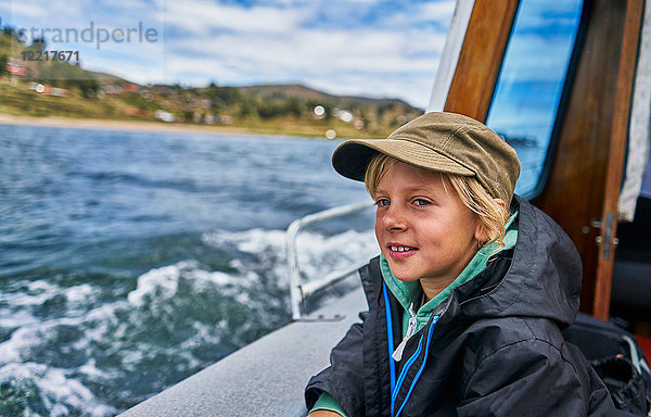 Junge schaut vom Motorboot auf das Meer hinaus  Puno  Peru