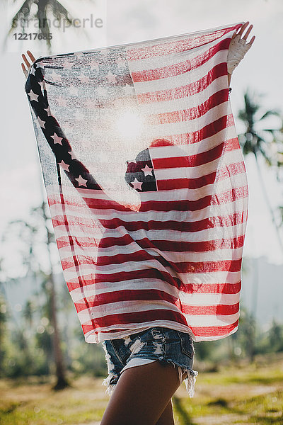 Junge Frau hält amerikanische Flagge hoch  Krabi  Thailand