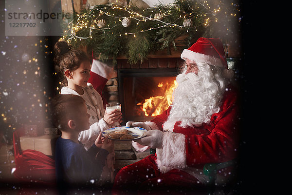 Ein Mädchen und ein Junge geben dem Weihnachtsmann Milch und Kekse