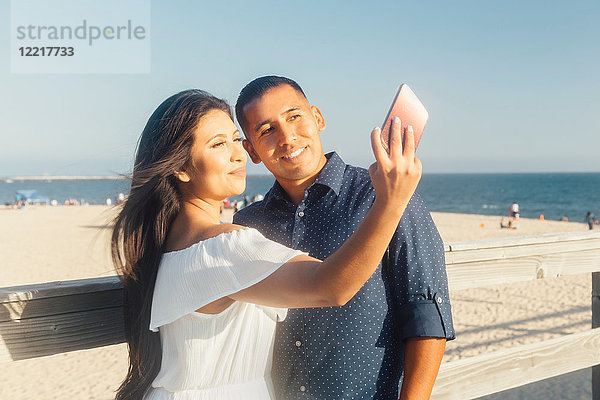 Paar am Strand  Selbstgespräch  mit Smartphone  Seal Beach  Kalifornien  USA