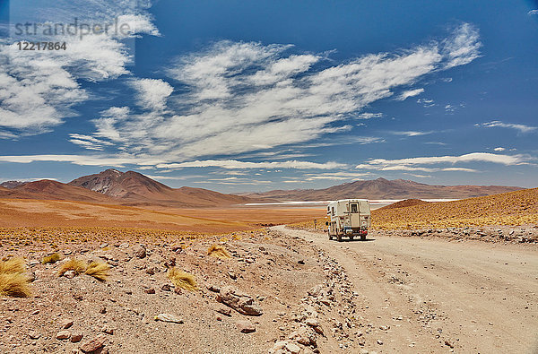 Freizeitfahrzeug bewegt sich durch die Landschaft  Rückansicht  Chalviri  Oruro  Bolivien  Südamerika