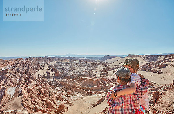 Junge und sein Bruder blicken über die Wüstenlandschaft  Atacama  Chile