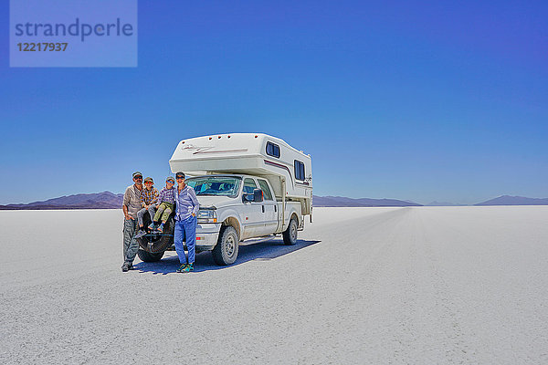 Familienporträt  stehend vor einem geparkten Wohnmobil  Salar de Uyuni  Uyuni  Oruro  Bolivien  Südamerika